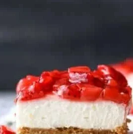No-Bake Strawberry Cheesecake Bars on a plate with fresh strawberries