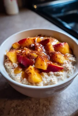 Delicious bowl of peach cobbler overnight oats topped with fresh peaches and spices