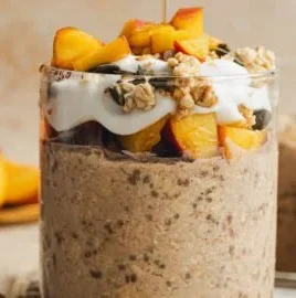 Bowl of Peach Cobbler Overnight Oats topped with peaches and spices