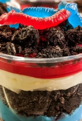 Layered red, white, and blue dirt cups with sprinkles and chocolate cookies.