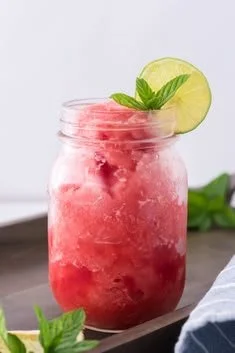 Refreshing watermelon slushie in a glass with ice and mint garnish
